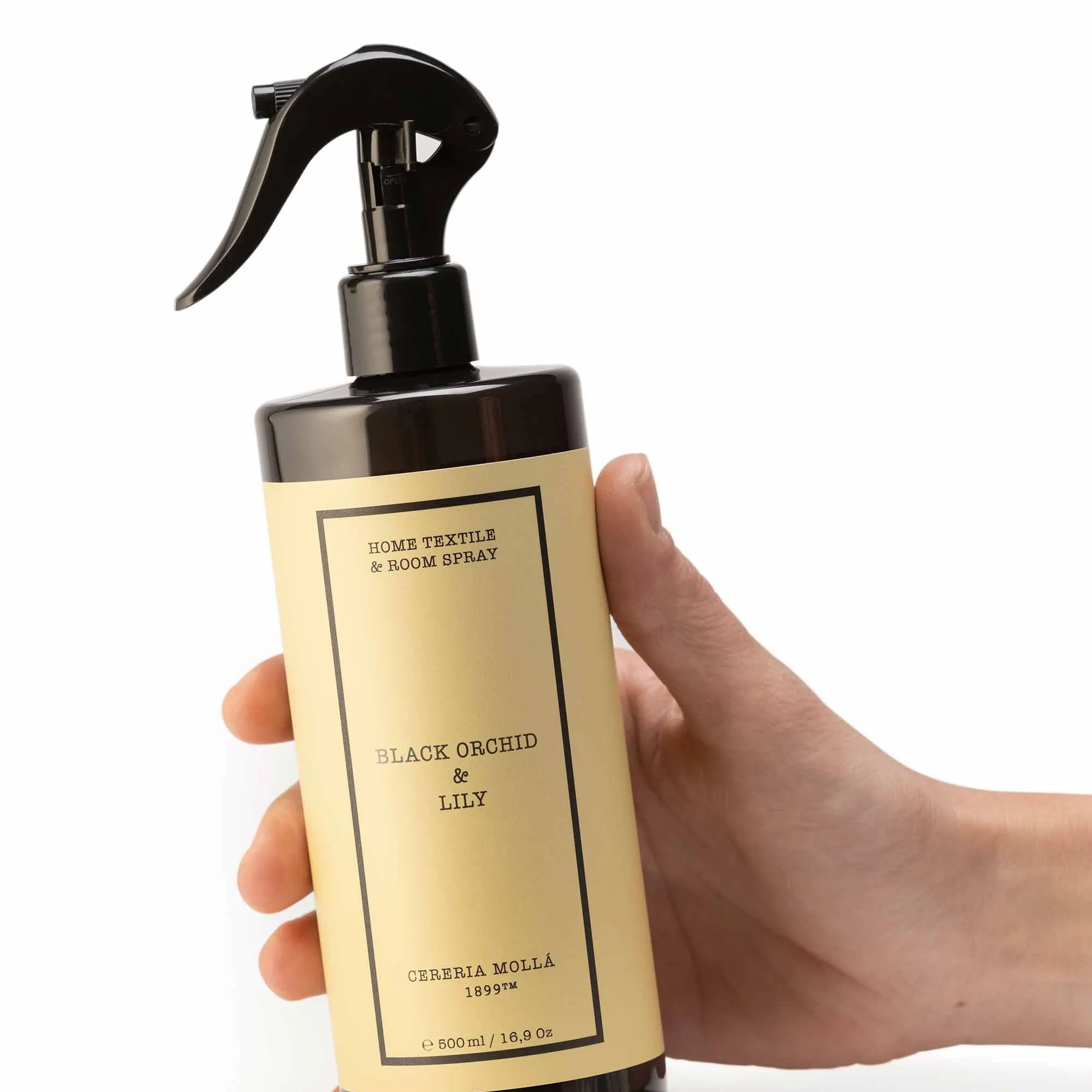 Mano sujetando el spray para tejidos y ambiente Black Orchid & Lily de Cerería Mollá